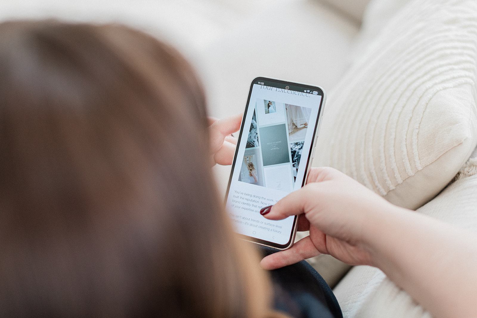 Sarah Shuttle holding a phone showing a luxury brand design website during the review stage