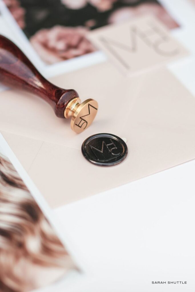Black wax seals with modern monogram and gold stamp, designed for a luxury beauty brand.