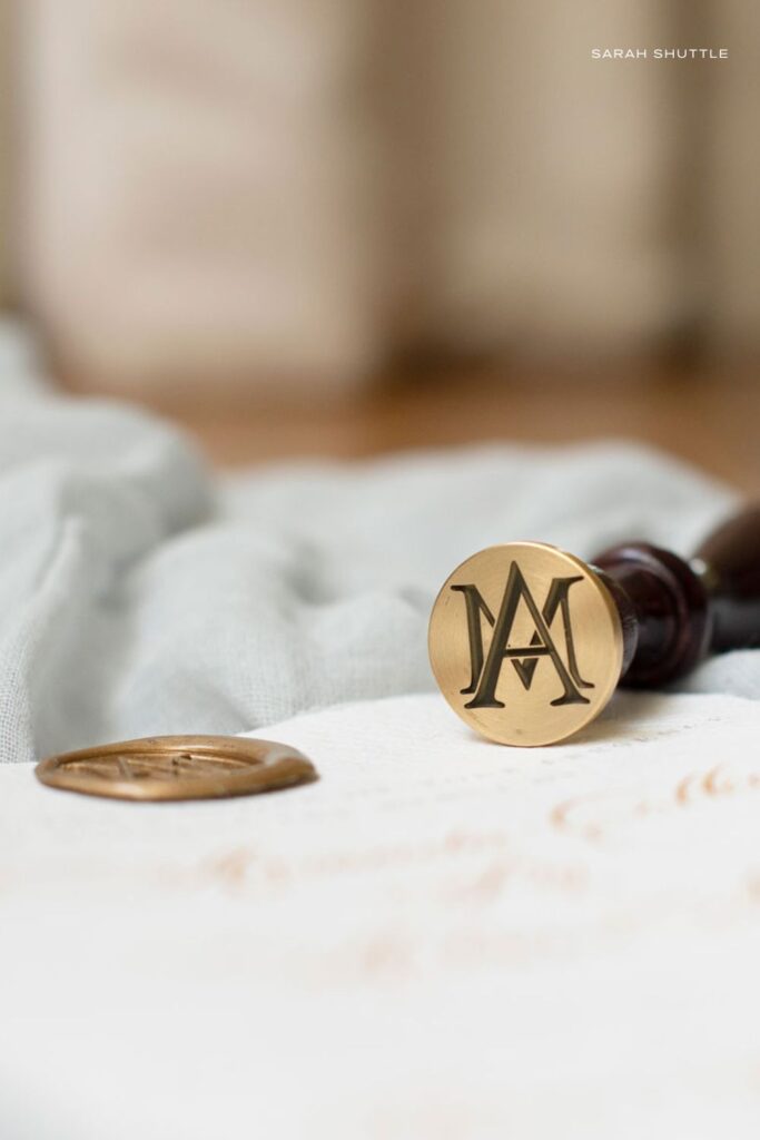 Gold wax seal featuring a bespoke monogram, designed for a fine art luxury heritage brand identity.