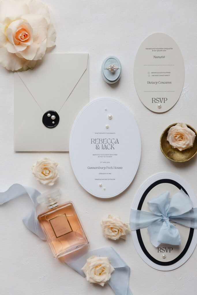 Flatlay of modern stationery and wedding details in blue, black and peach tones from a styled brand shoot.