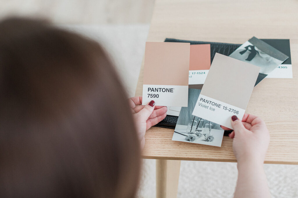 Sarah Shuttle, luxury brand designer, holding colour swatches while creating a warm and elegant brand identity.