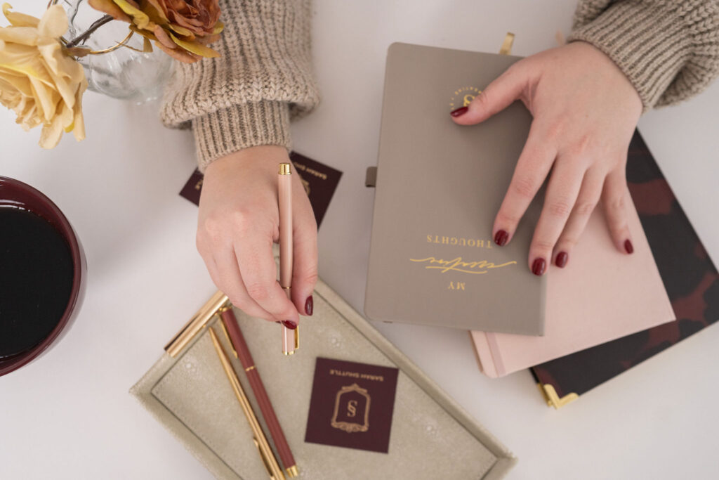 Sarah Shuttle working on luxury brand design at her desk with business cards and brand materials